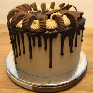 A chocolate cake with peanut butter and oreo cookies.