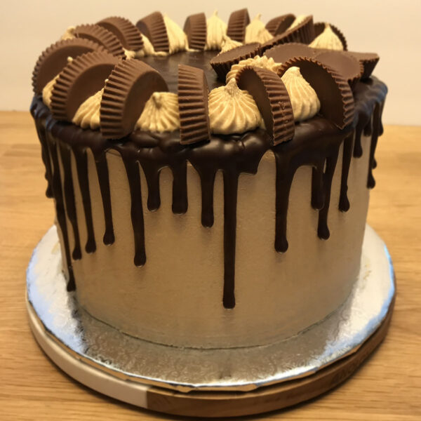 A chocolate cake with peanut butter and oreo cookies.