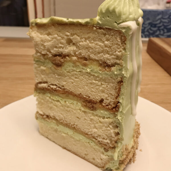 A slice of cake with green frosting on top.