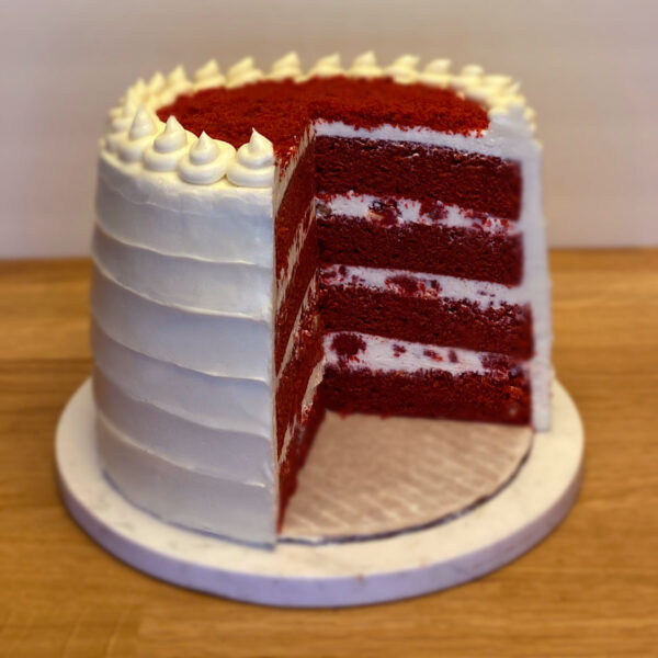 A red velvet cake with white frosting on top.