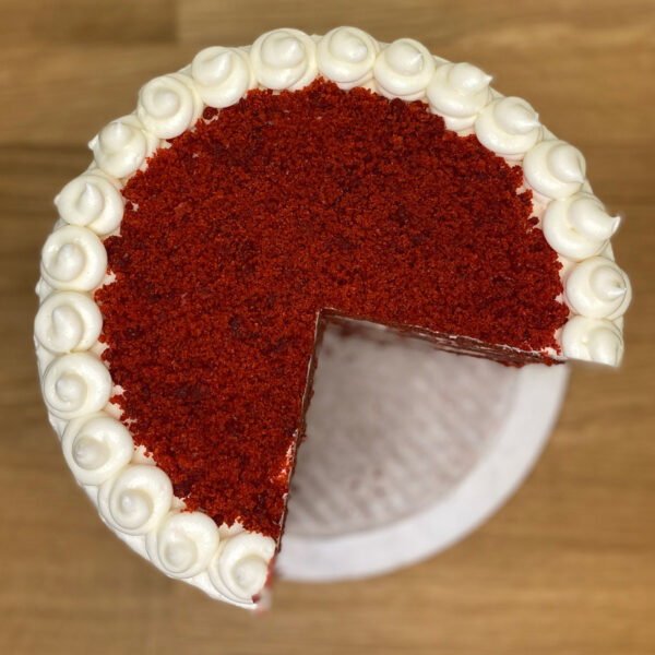 A red velvet cake with white frosting on top.
