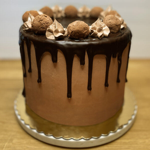 A chocolate cake with chocolate frosting and nuts.