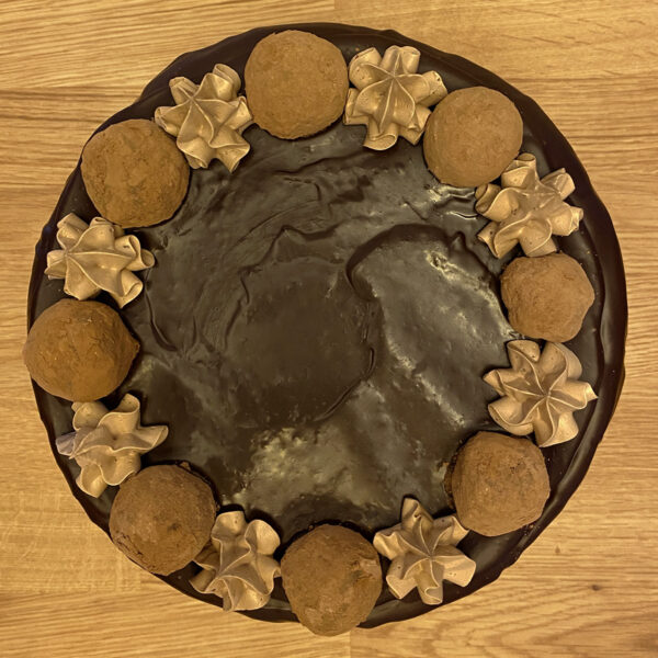 A round cake with chocolate frosting and cookies on top.