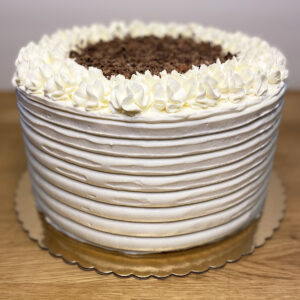 A white cake with chocolate frosting on top of a table.