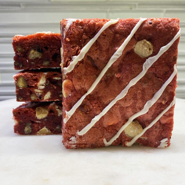A square piece of cake with white icing on top.