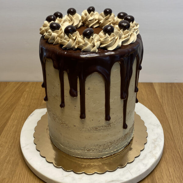 A cake with chocolate and white frosting on top of a gold plate.